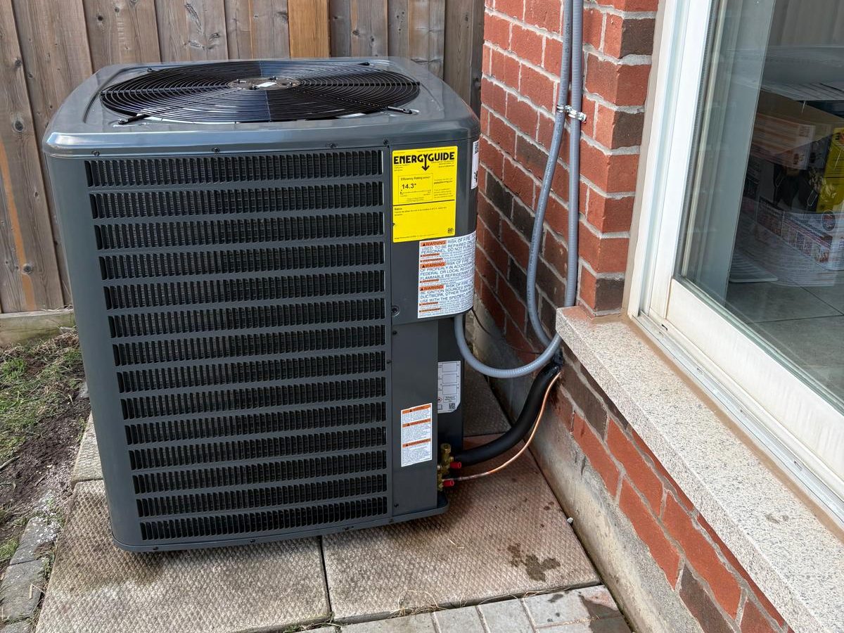 Central air conditioner installed beside a brick home